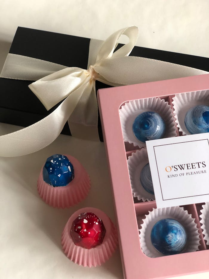 Elegant gift boxes with colorful truffles showcasing exquisite confectionery packaging.